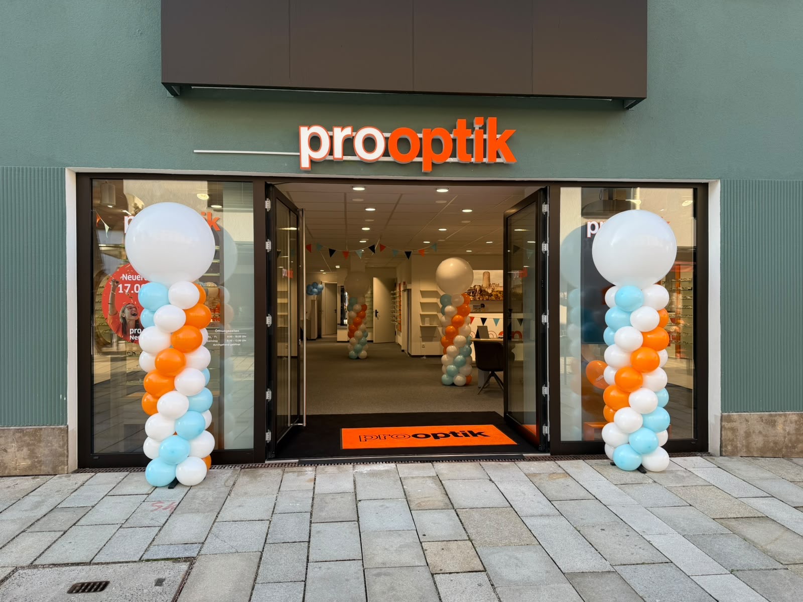 Ballonsäulen zur Neueröffnung von Prooptik mit weißem, hellblauem und orangefarbenem Ballondesign in Stuttgart